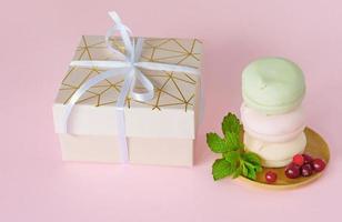 regalo scatola con fatti in casa pastello Multi colore marshmallows. Mela zeffiro nel il giro forma. delizioso frutta dolce su rosa sfondo foto