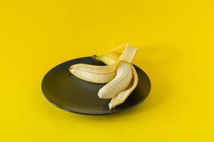 maturo Banana su nero piatto su giallo sfondo. tropicale frutta per mangiare foto