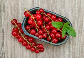 rosso ribes nel un' ciotola su di legno sfondo foto