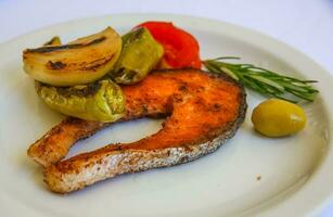 grigliato salmone su il piatto e bianca sfondo foto