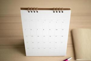 calendario pagina vicino su su legna tavolo sfondo con penna e taccuino attività commerciale pianificazione appuntamento incontro concetto foto