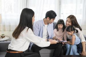 asiatico famiglia incontro con femmina vero tenuta agente o assicurazione consulente offerta promozioni , mutuo, prestito, proprietà e medico Salute assicurazione concetto. foto