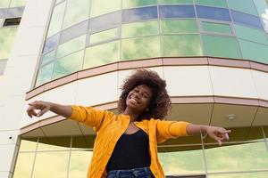 la felice e giovane donna afroamericana per strada che si diverte foto