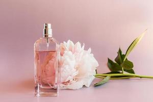 un' lussuoso bottiglia di Da donna profumo con Appunti di peonia. delicato floreale fragranza. il espressione di naturale odori. rosa sfondo. foto