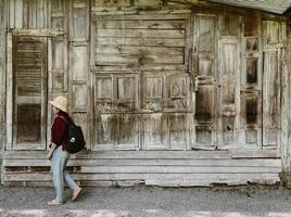 asiatico donna viaggio per Locale la zona con vecchio stile Casa fatto di legna foto