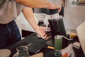 barista macinazione caffè fagioli nel caffè negozio. foto