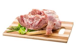 crudo agnello su di legno tavola e bianca sfondo foto