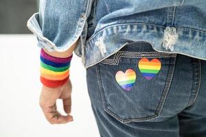 la signora asiatica con il cuore della bandiera arcobaleno, simbolo del mese dell'orgoglio lgbt, celebra l'annuale a giugno sociale di gay, lesbiche, bisessuali, transgender, diritti umani. foto