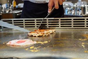 giapponese capocuoco cucinando carne nel teppanyaki ristorante foto