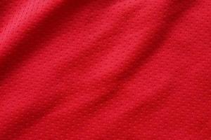 rosso gli sport capi di abbigliamento tessuto calcio camicia maglia struttura vicino su foto