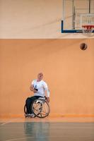 Disabilitato guerra veterani nel azione mentre giocando pallacanestro su un' pallacanestro Tribunale con professionale gli sport attrezzatura per il Disabilitato foto