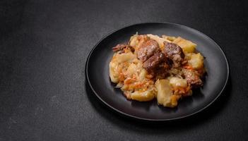 delizioso verdura stufato con manzo, patate, carote e cavolo nel un' nero piatto foto