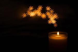 aromatico candela con fiamma e fiocco di neve forma bokeh su buio sfondo per Grazie dando e Natale giorno. foto