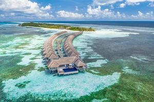 sorprendente isola spiaggia. Maldive a partire dal aereo Visualizza tranquillo tropicale paesaggio mare con palma alberi su bianca sabbioso spiaggia. esotico natura costa, lusso ricorrere isola. bellissimo estate vacanza turismo foto