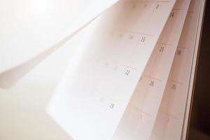 calendario pagina capovolgimento foglio vicino su sfocatura sfondo attività commerciale programma pianificazione appuntamento incontro concetto foto