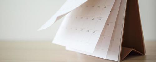 calendario pagina capovolgimento foglio su legna tavolo sfondo attività commerciale programma pianificazione appuntamento incontro concetto foto