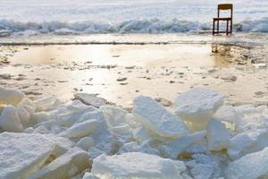 ghiaccio blocchi e sedia su bordo di buco nel ghiaccio foto