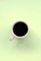 piccolo bianca caffè tazza su struttura sfondo di moda pastello lime colore carta foto