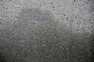 sfondo Immagine di pioggia gocce su un' bicchiere finestra, quale è protetta di un' zanzara rete. macro foto con superficiale profondità di campo