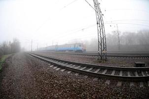 il ucraino suburbano treno si precipita lungo il ferrovia nel un' nebbioso mattina. fisheye foto con è aumentato distorsione