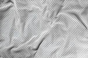 sport capi di abbigliamento tessuto struttura sfondo. superiore Visualizza di bianca poliestere nylon stoffa tessile superficie. colorato pallacanestro camicia con gratuito spazio per testo foto