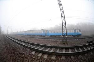 il ucraino suburbano treno si precipita lungo il ferrovia nel un' nebbioso mattina. fisheye foto con è aumentato distorsione