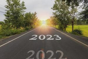 autostrada concetto per attività commerciale pianificazione, il parola 2023 scritto su autostrada strada nel il mezzo di vuoto asfalto strada a d'oro tramonto e bellissimo blu cielo. foto