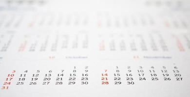 vicino su calendario pagina date astratto sfocato sfondo attività commerciale pianificazione appuntamento incontro concetto foto