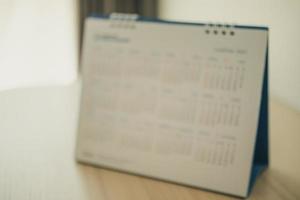 sfocatura calendario pagina vicino su su legna tavolo sfondo attività commerciale pianificazione appuntamento incontro concetto foto