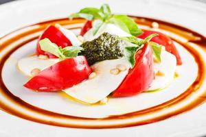 caprese insalata con Mozzarella, pomodoro, basilico e pesto foto