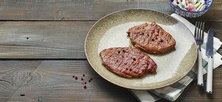 Due grigliato ribeye bistecche, spezie e pomodoro-cetriolo insalata con acida crema foto