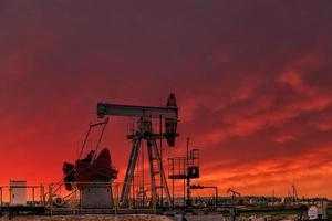 olio trapano impianto e pompa Jack a tramonto sfondo. foto