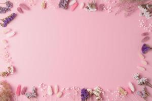 cosmetico sfondo con fiori su rosa. piatto posizione, copia spazio foto