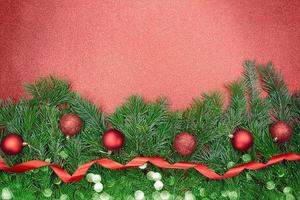 abete rami con rosso brillante e Opaco palle, nastro con bokeh su scintillante sfondo. Natale, nuovo anno. copia spazio foto