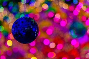 blu fronzolo sospeso per decorare per Natale vacanza con colorato bokeh a partire dal leggero e altro palline. foto