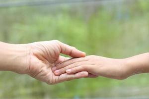 famiglia porzione - bambino mano mettere su madre mano con amore e cura foto