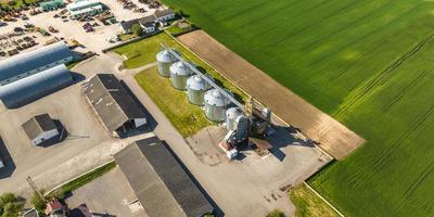 vista aerea su agro silos ascensore per granaio su impianto di produzione agro-industriale per la lavorazione, asciugatura, pulitura e stoccaggio di prodotti agricoli, farina, cereali e grano. foto