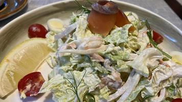 un' grande piatto con frutti di mare insalata su il tavolo foto