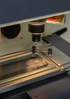 un' verticale avvicinamento tiro di un illuminato microscopio a un' medico produzione magazzino foto
