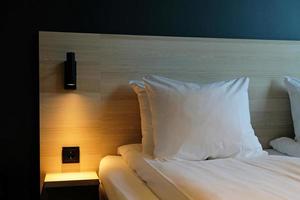 un' frammento di un' Camera da letto con un' moderno accogliente interno design di un' Casa o Hotel. morbido cuscino e lenzuolo, elegante confortevole arredamento. foto