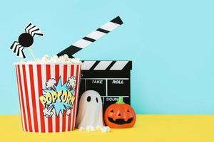 Halloween concetto sfondo. film ciak con Popcorn, divertente Halloween zucca e Halloween fantasma. Halloween film concetto foto