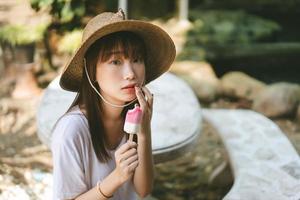 donna asiatica dell'adolescente che mangia il gelato al giardino all'aperto. foto