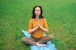 maturo mezzo anziano in forma salutare donna praticante yoga al di fuori nel naturale calma foto