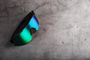 gli sport bicchieri con un' verde rispecchiato lente e nero montatura su un' nero sfondo foto
