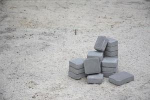 piccolo mucchio di grigio passerella lastre dire bugie nel pila all'aperto. Materiale per pavimentazione lastre di mosaico nel progresso. ciottolo installazione foto