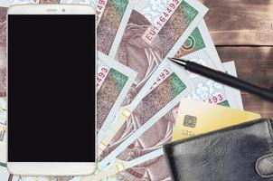 10 polacco zloty fatture e smartphone con borsa e credito carta. pagamenti elettronici o e-commerce concetto. in linea shopping e attività commerciale con portatile dispositivi foto