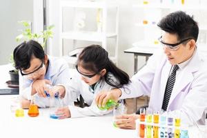 selettivo messa a fuoco a ragazzo viso. giovane asiatico ragazzo e ragazza studia scienza classe utilizzando microscopio e chimico liquido per fare il sperimentare dentro laboratorio. formazione scolastica concetto. foto