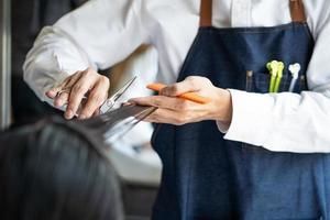 vicino su tiro a mano di capelli elegante mentre fare capelli tagliare e capelli costumista e trattamento mentre messa in piega capelli per cliente. professionale occupazione, bellezza e moda servizio occupazione. foto