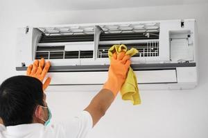asiatico uomo pulizia aria condizionatore con microfibra stoffa foto