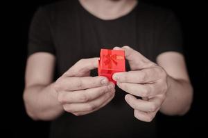 l'uomo fa un regalo in una confezione regalo rossa su st. San Valentino foto